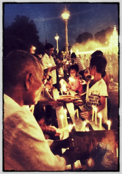 Mourners light candles (Royal Palace at night)